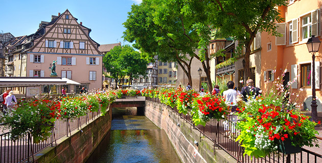 Bäume und blühende Blumenkästen an Fluss in Colmar