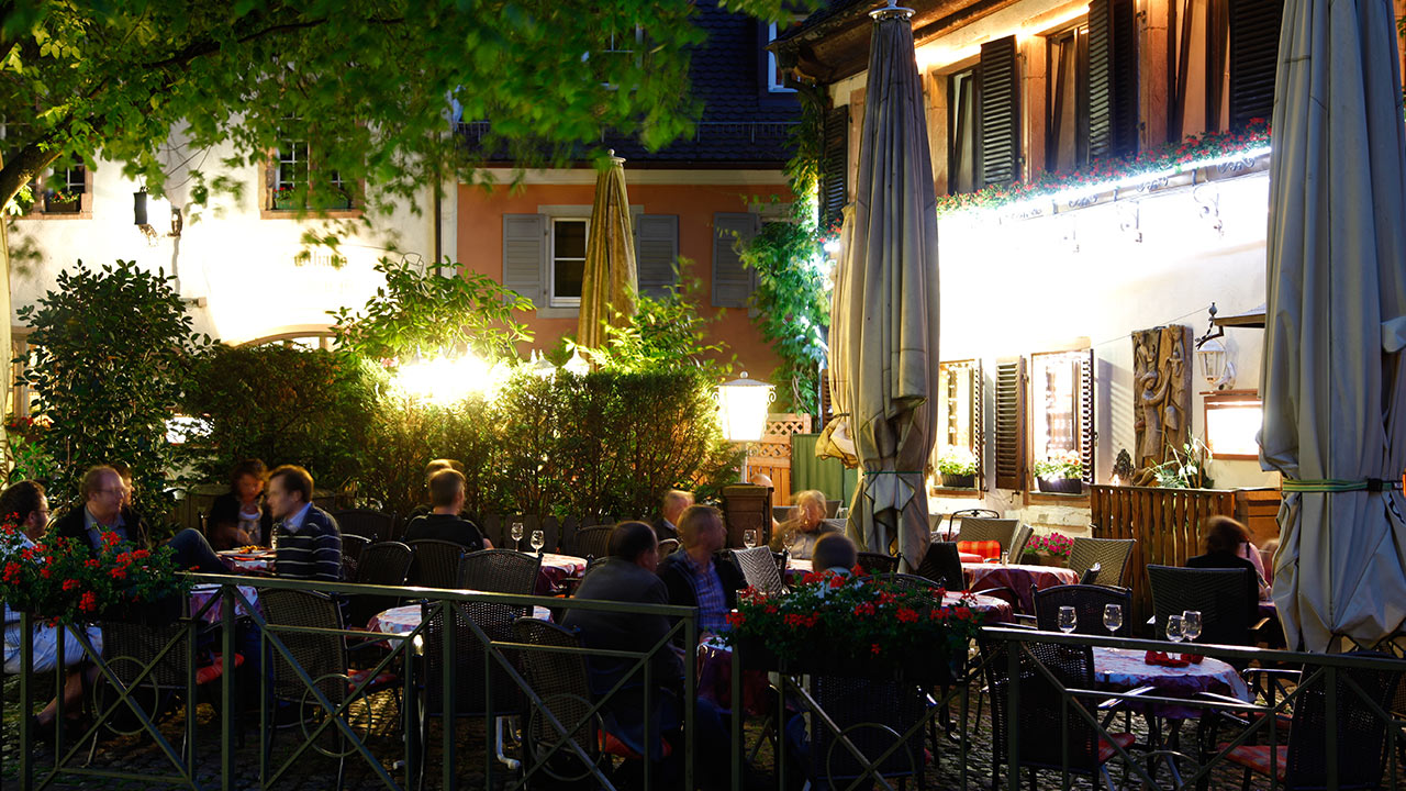 Restaurant-Gäste in umzäunter Außenbereich bei Nacht in Freiburg in Breisgau