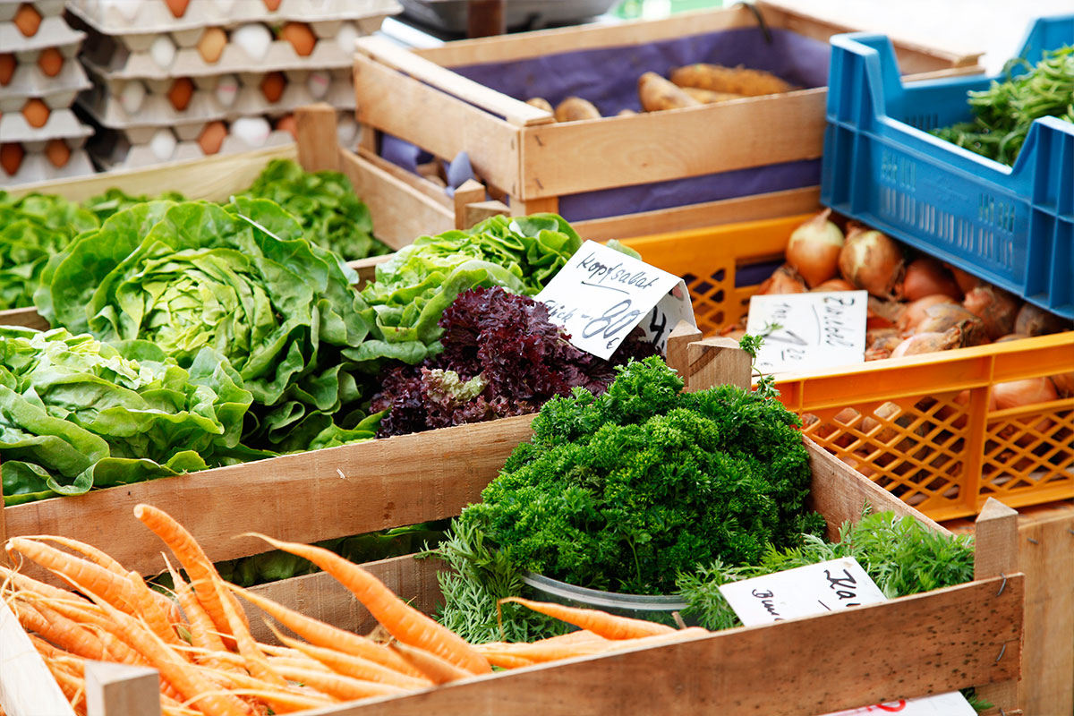 Karotten, Salate und Zwiebeln in Kästen auf dem Wochenmarkt