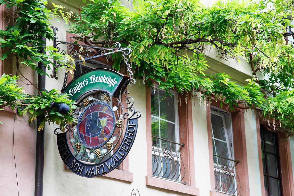 Schild des Hotel Schwarzwälder Hof in Freiburg mit Kletterpflanze